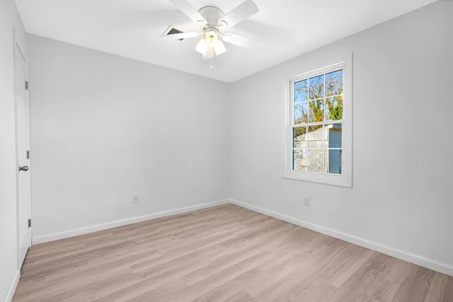 a view of an empty room with wooden floor
