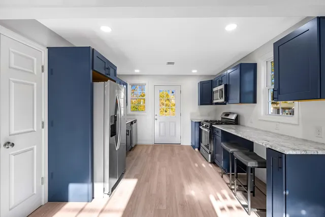 a kitchen with stainless steel appliances a stove a sink a microwave and wooden cabinets