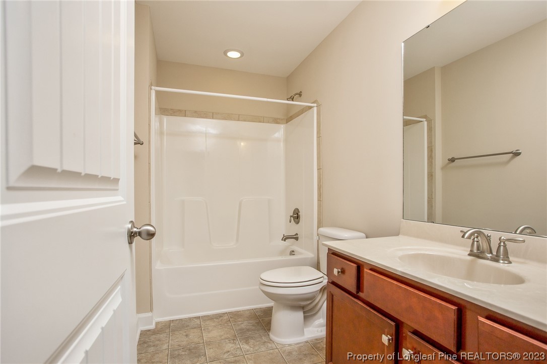 157 Shellbark Drive Spring Lake, NC 28390 - Photo 18 of 28 a bathroom with a granite countertop sink toilet a shower and a mirror