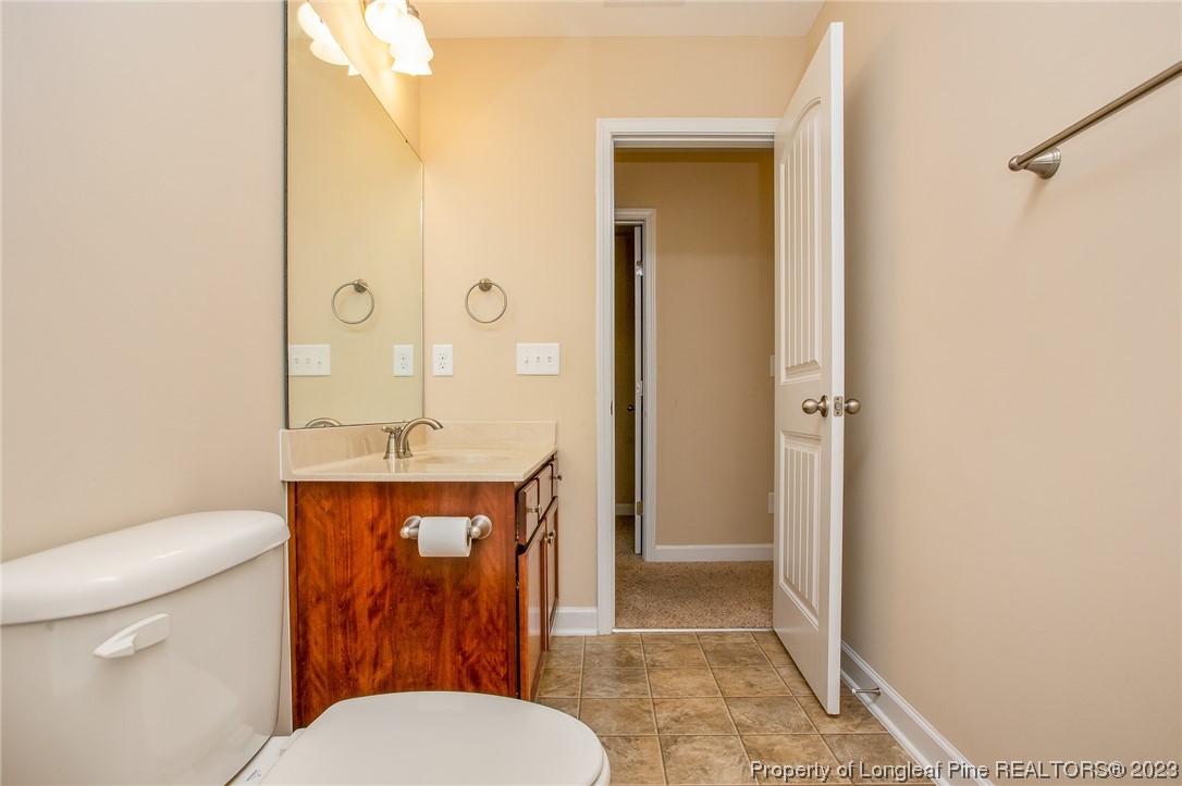 157 Shellbark Drive Spring Lake, NC 28390 - Photo 19 of 28 a bathroom with a granite countertop toilet a sink and a mirror