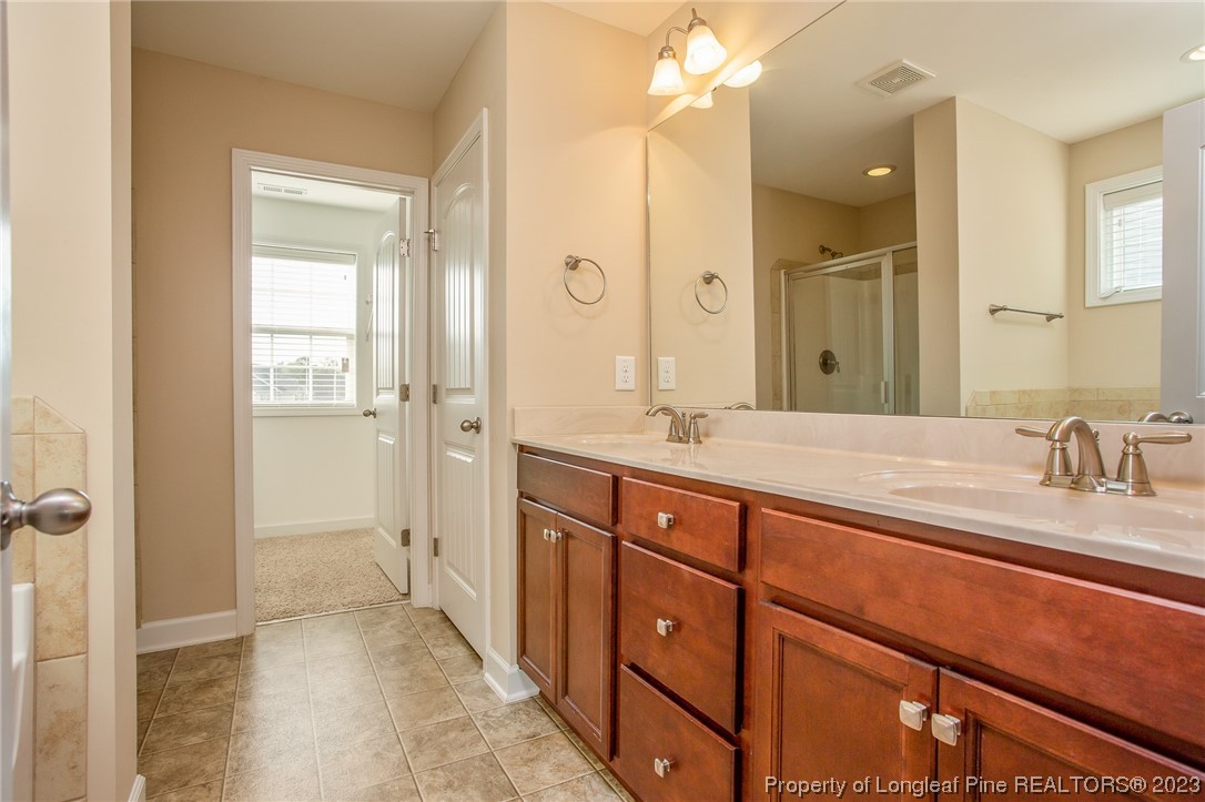 157 Shellbark Drive Spring Lake, NC 28390 - Photo 25 of 28 a spacious bathroom with a shower sink and mirror