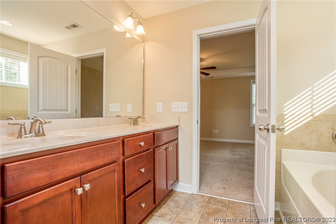 157 Shellbark Drive Spring Lake, NC 28390 - Photo 26 of 28 a spacious bathroom with a tub sink and mirror