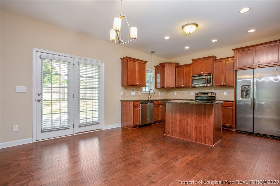 157 Shellbark Drive Spring Lake, NC 28390 - Photo 8 of 28 a kitchen with stainless steel appliances granite countertop a refrigerator a sink dishwasher a stove and a refrigerator with wooden floor