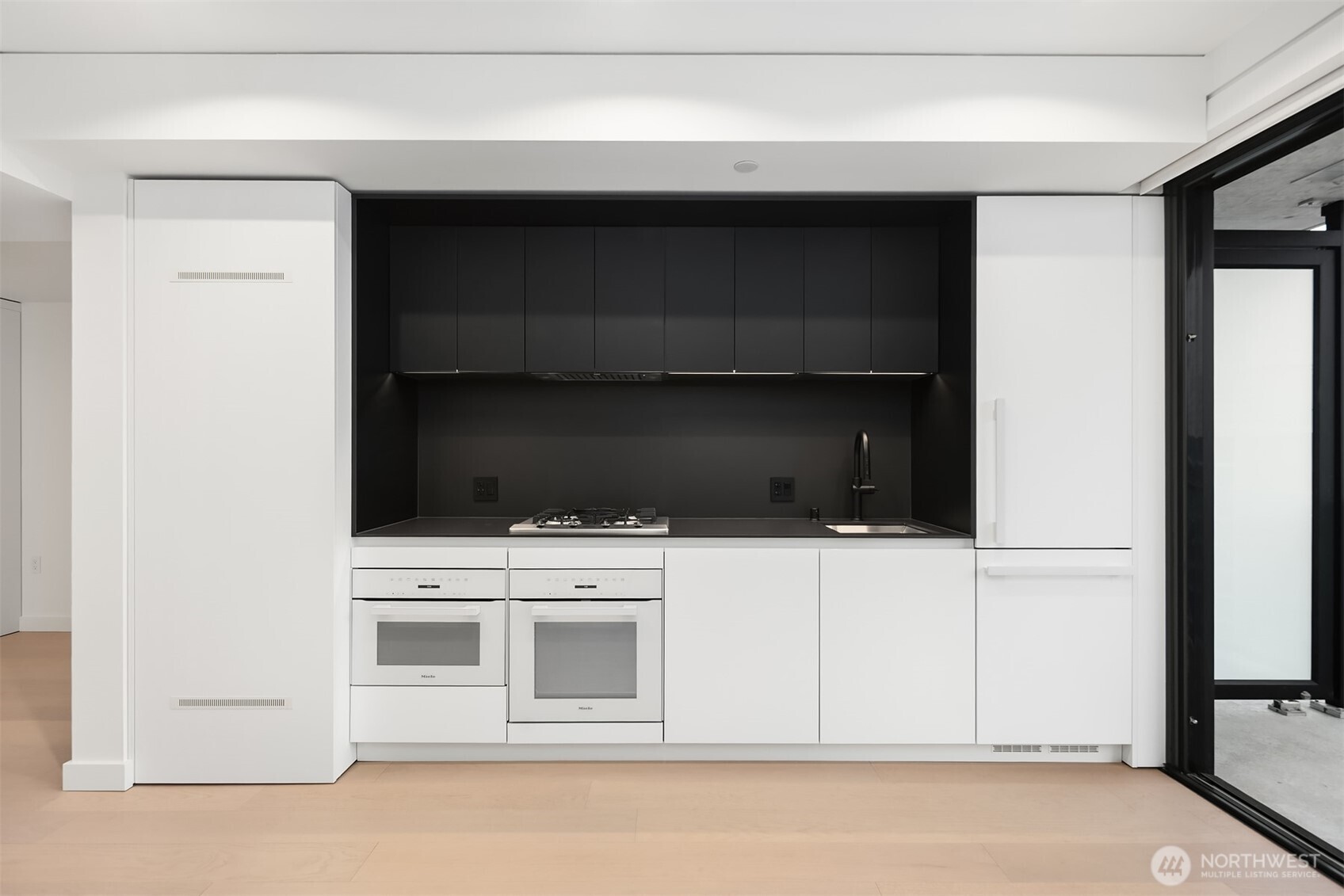 300 Virginia Street, Unit 3103 Seattle, WA 98101 - Photo 4 of 36 a kitchen with white cabinets and black appliances
