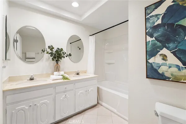 a bathroom with a double vanity sink mirror and bathtub