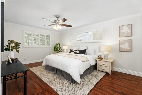 a bedroom with a large bed and a potted plant