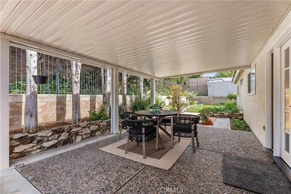 a room with patio furniture and a potted plant