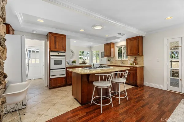 a kitchen with a dining table chairs and refrigerator
