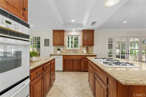 a kitchen with stainless steel appliances granite countertop a stove a sink and a microwave