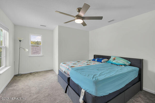 136 Peace River Road St. Johns, FL 32259 - Photo 26 of 40 a bedroom with a bed and a chandelier