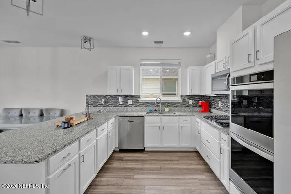 a kitchen with stainless steel appliances granite countertop a sink stove and wooden cabinets