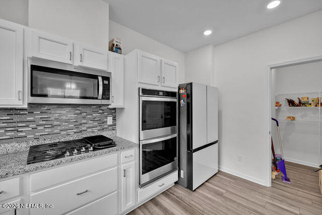 136 Peace River Road St. Johns, FL 32259 - Photo 10 of 40 a kitchen with microwave a stove and cabinets