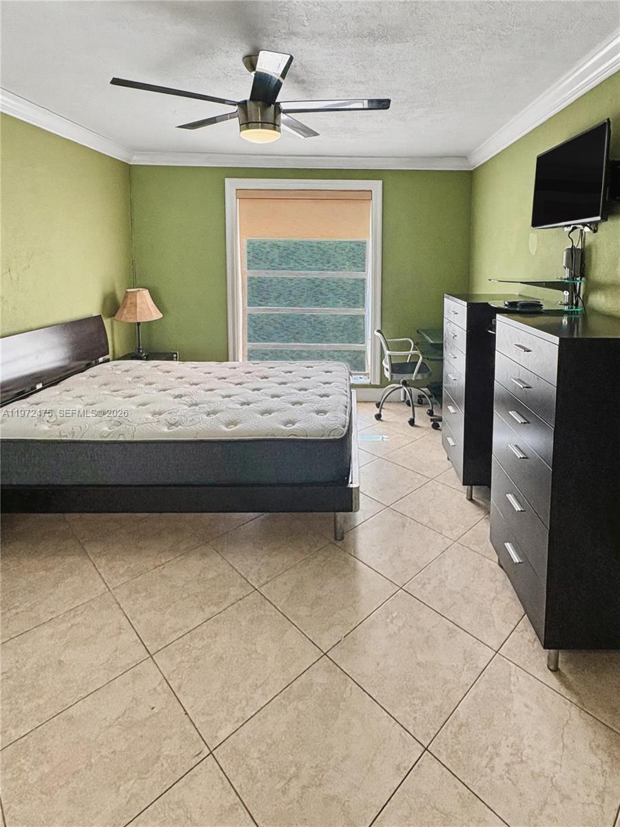 9417 Southwest 76th Street, Unit X36 Miami, FL 33173 - Photo 3 of 10 a bedroom with a bed and flat screen tv