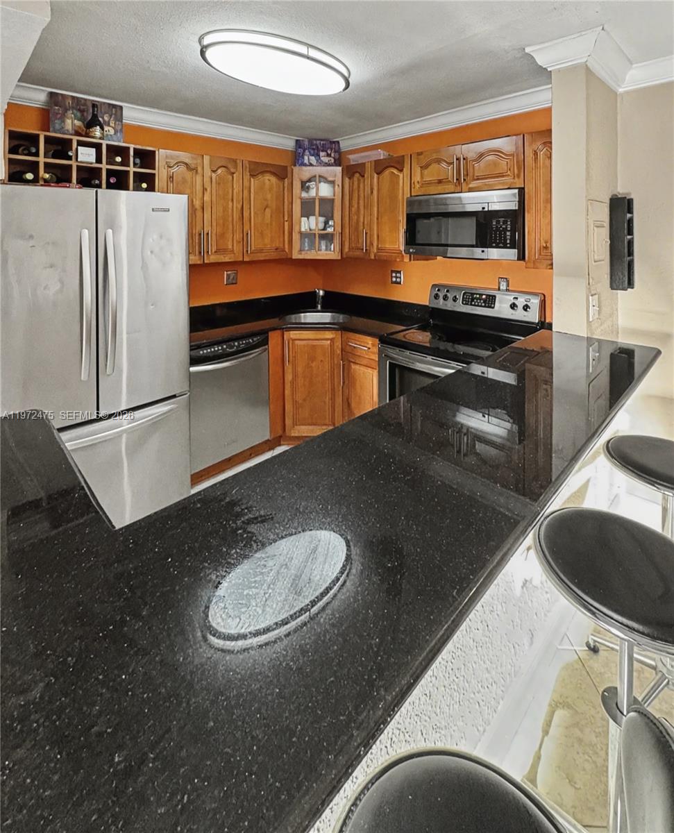 9417 Southwest 76th Street, Unit X36 Miami, FL 33173 - Photo 7 of 10 a kitchen with stainless steel appliances granite countertop a sink a stove and a refrigerator