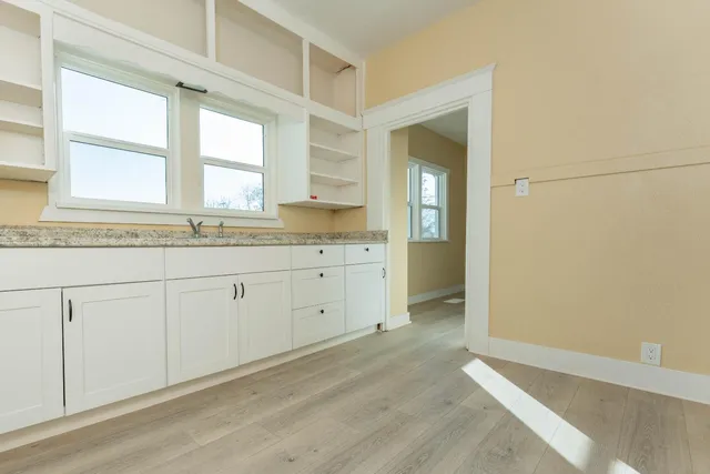 a view of an empty room with wooden floor
