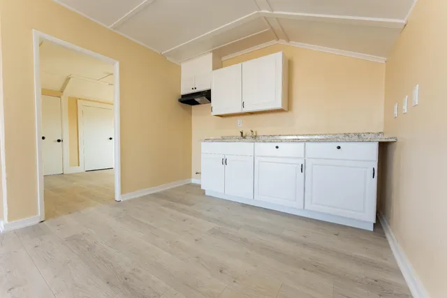 a view of a big room with wooden floor and windows