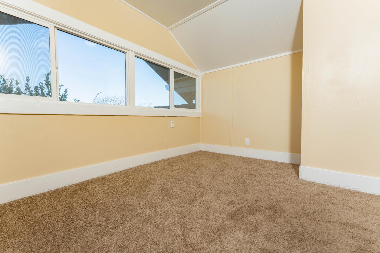 4354 East Kings Canyon Road Fresno, CA 93702 - Photo 45 of 70 a view of an empty room with wooden floor and a window