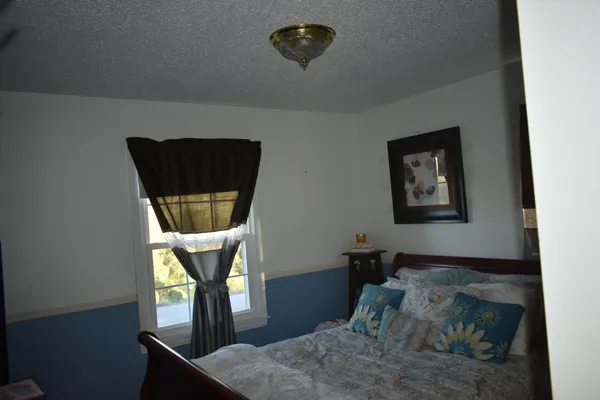 a bedroom with a bed a mirror and window