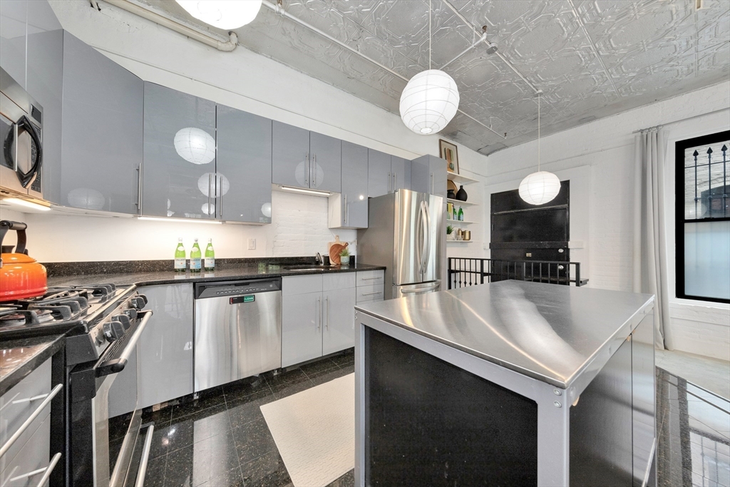 10 Williams Street, Unit 13 Boston, MA 02119 - Photo 22 of 38 a kitchen with a sink stainless steel appliances and cabinets