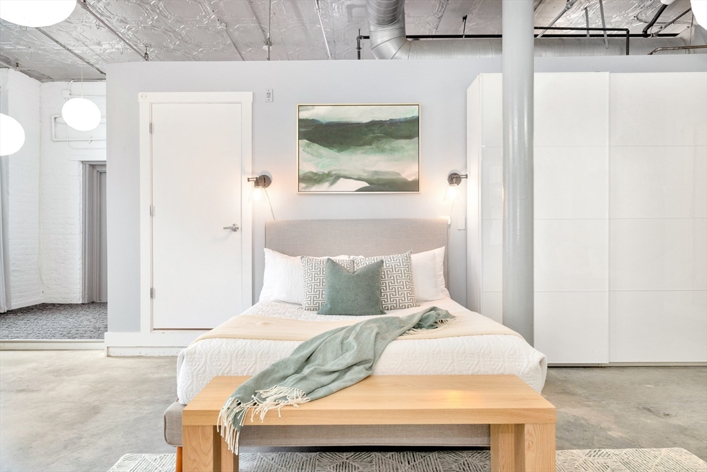 10 Williams Street, Unit 13 Boston, MA 02119 - Photo 8 of 38 a bedroom with a bed and a painting on the wall