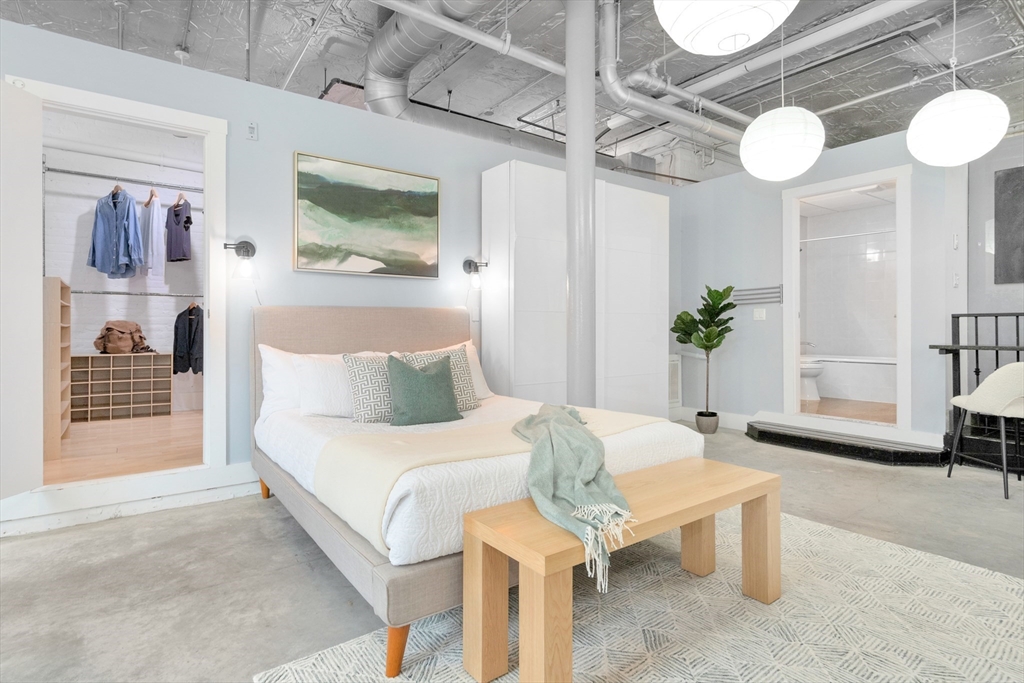 10 Williams Street, Unit 13 Boston, MA 02119 - Photo 9 of 38 a bedroom with a bed and a chandelier