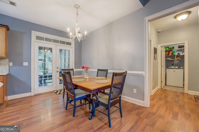 a dining room with furniture a chandelier and wooden floor