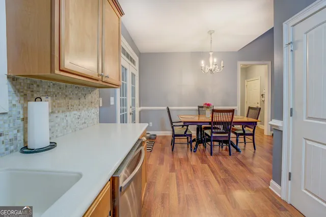 a kitchen with stainless steel appliances granite countertop wooden cabinets a sink and dishwasher a refrigerator with wooden floor