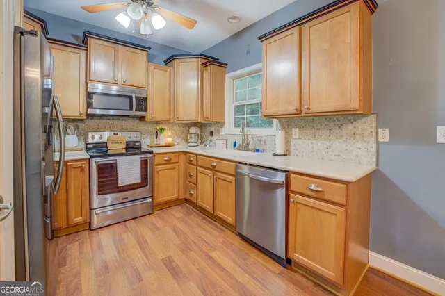 a kitchen with stainless steel appliances granite countertop a refrigerator a stove top oven a sink and dishwasher