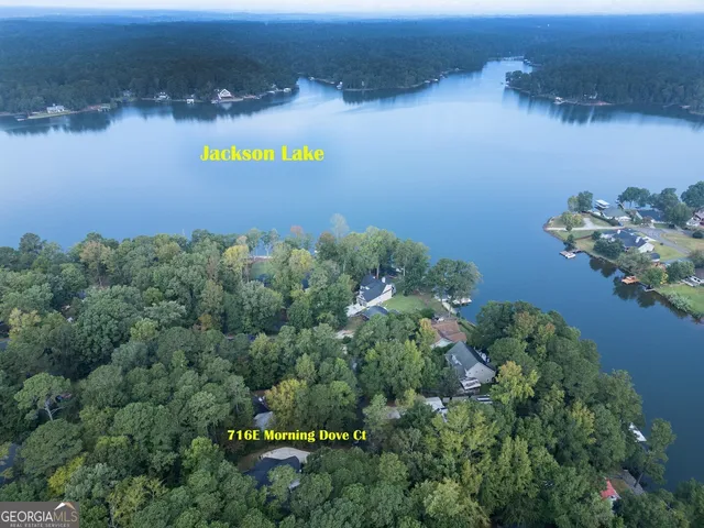 an aerial view of a house with a yard and lake view