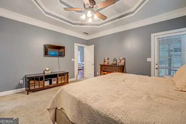 a bedroom with a bed a dresser and a chandelier