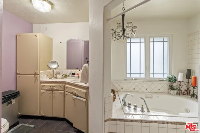 a bathroom with a tub sink and mirror