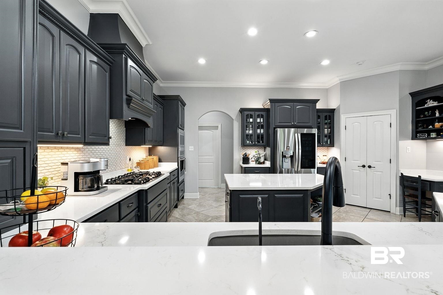 23357 Carnoustie Drive Foley, AL 36535 - Photo 35 of 99 Kitchen with arched walkways, stainless steel appliances, backsplash, crown molding, and glass insert cabinets