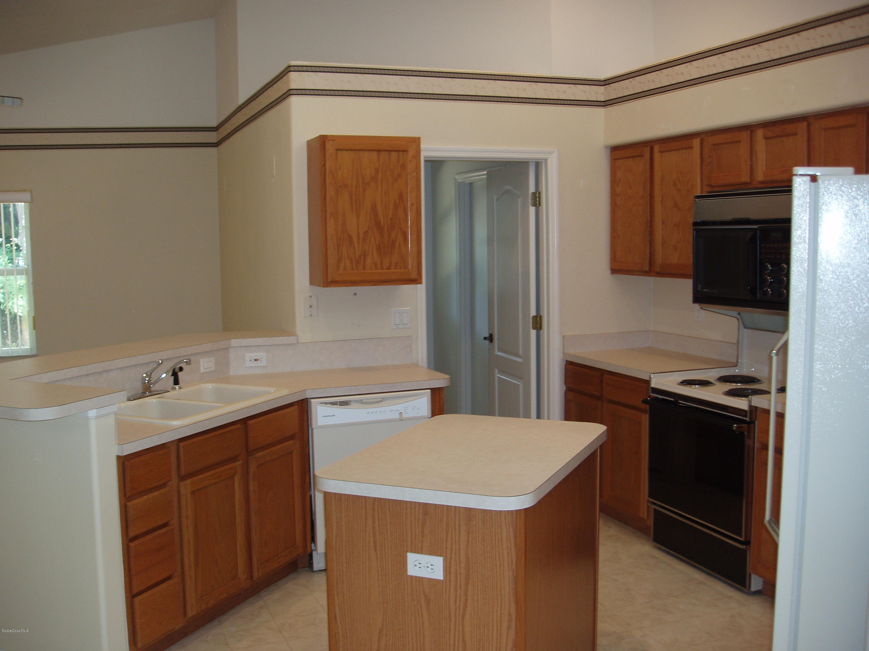 740 Riviera Drive Northeast Palm Bay, FL 32905 - Photo 4 of 30 Kitchen to Laundry Rm & Pantry