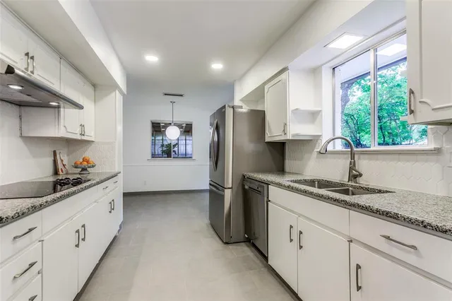 a kitchen with stainless steel appliances granite countertop a sink stove and refrigerator