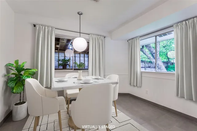 a dining room with wooden floor a chandelier a glass table and chairs