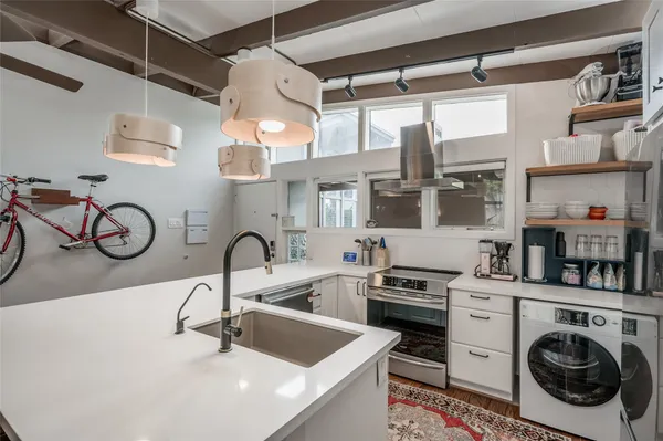 a kitchen with a sink a stove and cabinets
