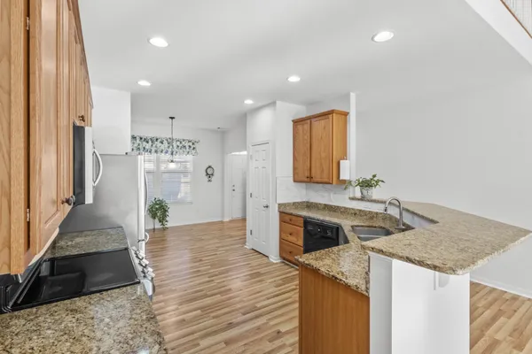 a kitchen with stainless steel appliances granite countertop a refrigerator stove microwave and sink