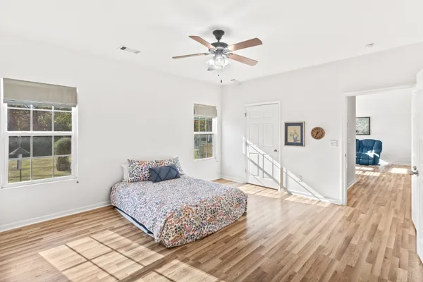 a view of a livingroom with wooden floor and a ceiling fan