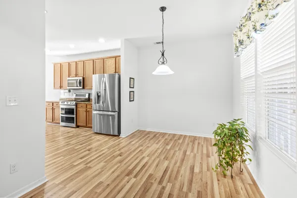 a kitchen with stainless steel appliances granite countertop a refrigerator a stove and a wooden floors