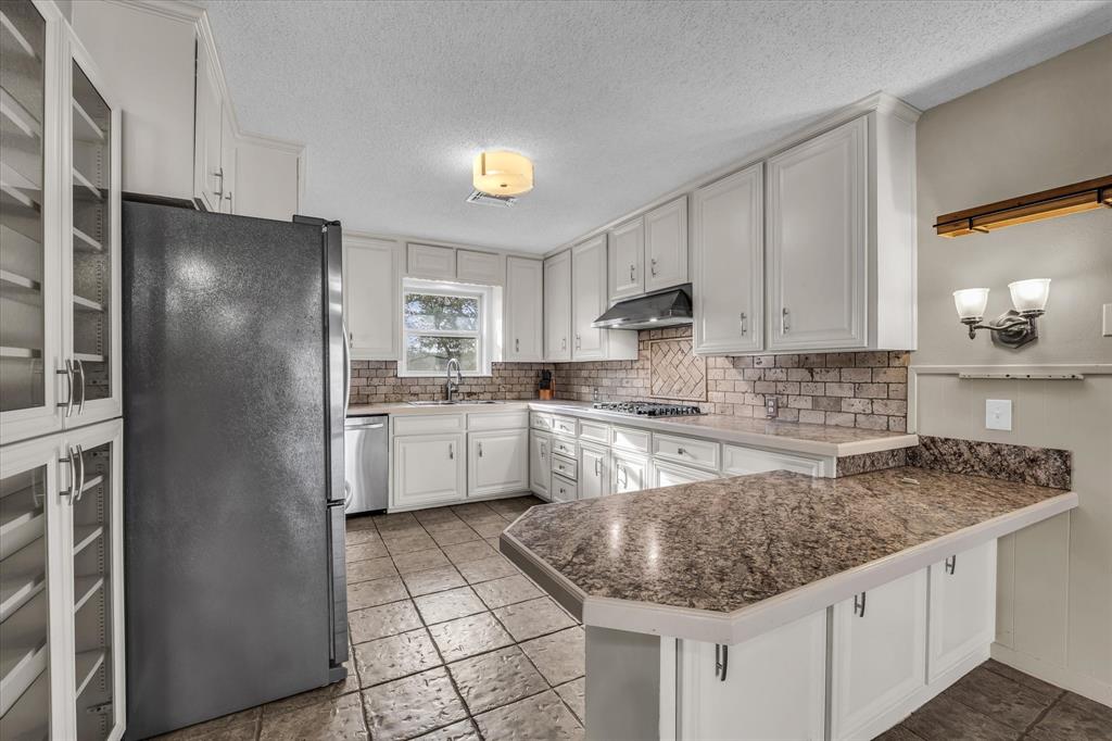 4325 Shady Glen Drive Waco, TX 76708 - Photo 7 of 40 a kitchen with stainless steel appliances granite countertop a sink stove and refrigerator