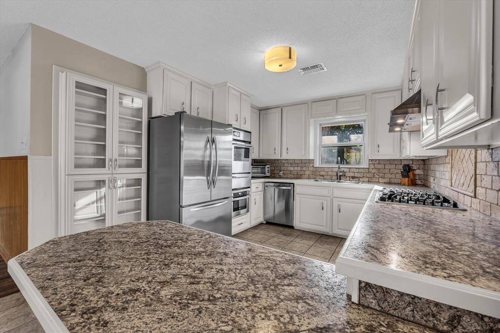 4325 Shady Glen Drive Waco, TX 76708 - Photo 8 of 40 a kitchen with stainless steel appliances granite countertop a sink refrigerator and cabinets