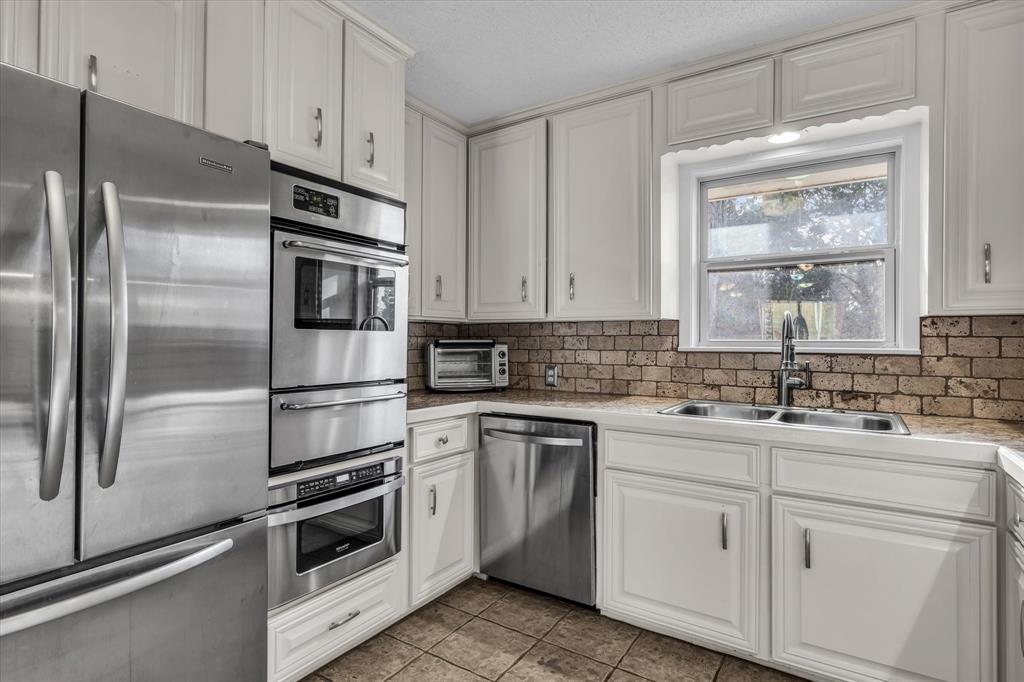 4325 Shady Glen Drive Waco, TX 76708 - Photo 9 of 40 a kitchen with cabinets stainless steel appliances and window