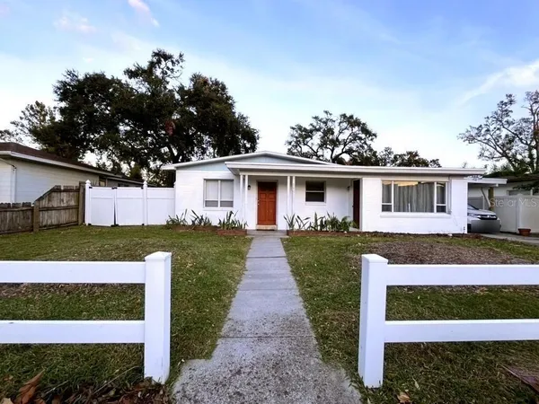 a front view of a house with a garden and yard