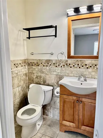 a bathroom with a toilet sink and mirror