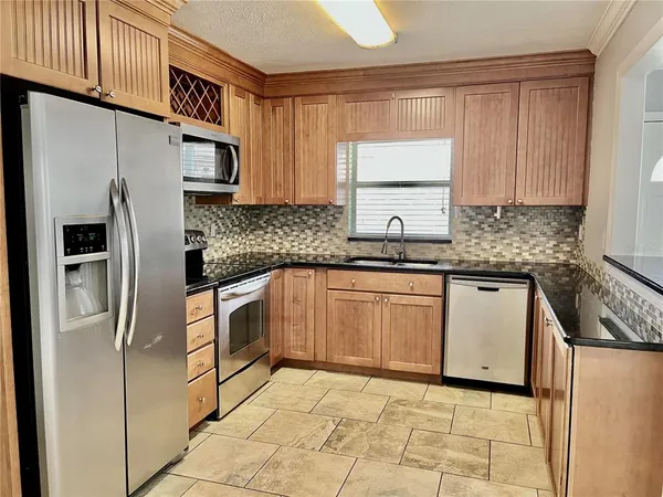 a kitchen with stainless steel appliances granite countertop a refrigerator sink and cabinets