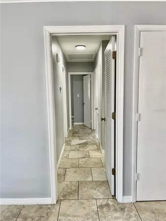 a view of a hallway with wooden floor and a bathroom