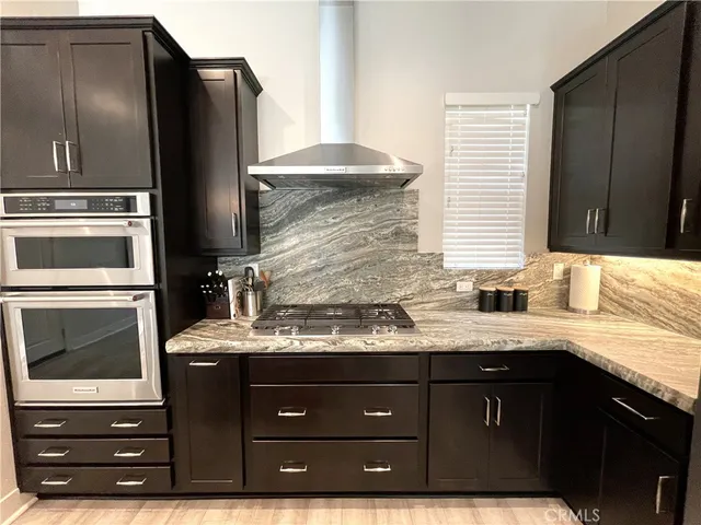a kitchen with a granite countertop sink and white cabinets