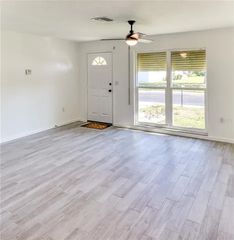 a view of a house with a yard and large trees
