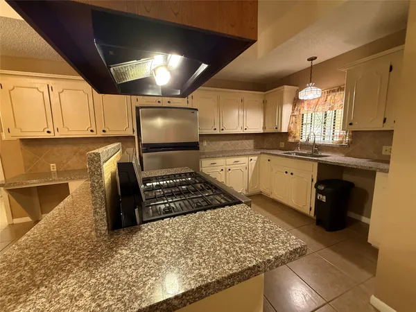 a kitchen with granite countertop a sink stainless steel appliances and cabinets