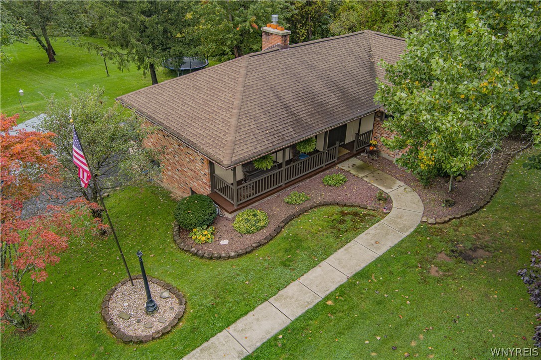 6775 Bear Ridge Road Pendleton, NY 14094 - Photo 41 of 48 Mature trees frame a classic brick home with an inviting front porch and stone walkway.